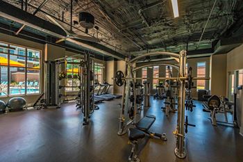 A gym with a variety of equipment including treadmills, weights, and exercise machines at The Collective NoDa, Charlotte